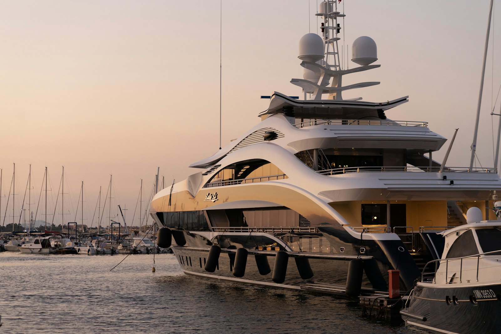A superyacht moored in a harbour at golden hour